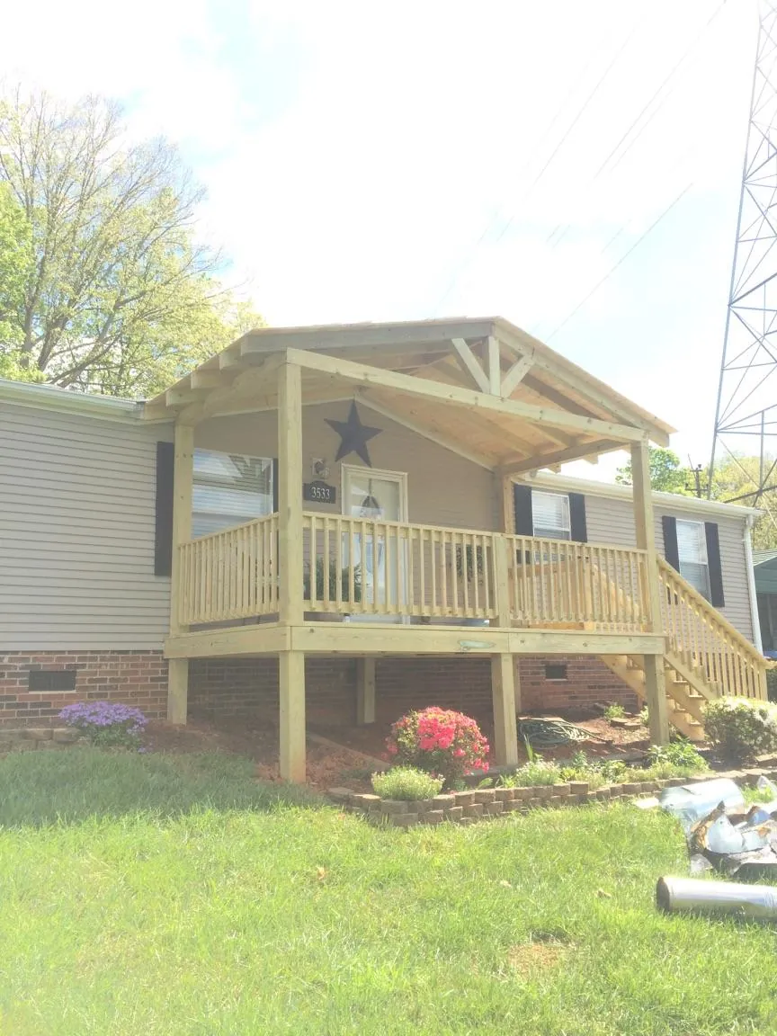 New gabled porch roof and deck railing added to a ranch home in Newton